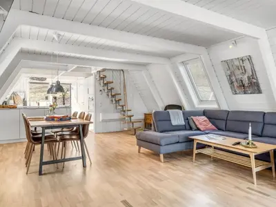 a living room with a blue couch and a table at Apartment Kauno - 16km to the fjord by Interhome in Farsø