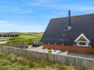 a red brick house with a table and chairs at Holiday Home Arkil - 200m from the sea by Interhome in Harboør