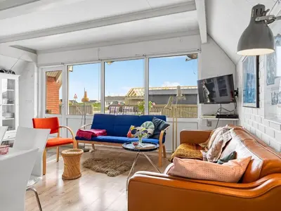 a living room with a couch and a table at Holiday Home Arkil - 200m from the sea by Interhome in Harboør