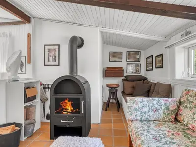 a living room with a fireplace and a couch at Holiday Home Rieke - 2km from the sea by Interhome in Blokhus