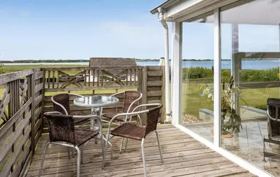 a patio with a table and chairs on a deck at Nice Home In Roslev With House Sea View in Roslev