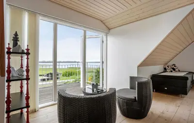 a bedroom with a bed and a large window at Nice Home In Roslev With House Sea View in Roslev