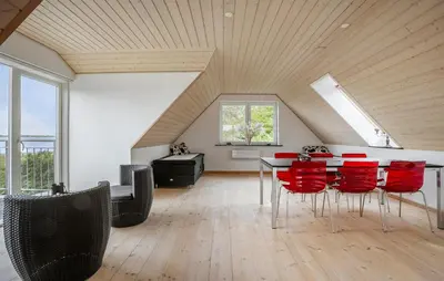 a dining room with a table and red chairs at Nice Home In Roslev With House Sea View in Roslev