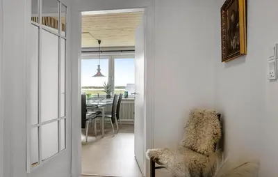 a hallway leading into a dining room with a chair at Nice Home In Roslev With House Sea View in Roslev