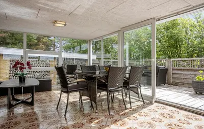 a screened in porch with a table and chairs at Nice Home In Roslev With House Sea View in Roslev