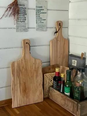two wooden cutting boards sitting on a table with bottles at Traditional Summer House Near Blokhus Beach in Blokhus