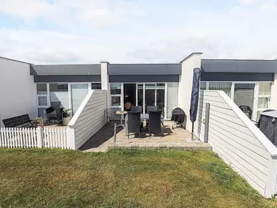 a house with a deck with a table and chairs at 4 person holiday home in Vestervig in Vestervig