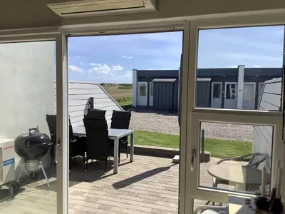 a sliding glass door of a patio with a table and chairs at 4 person holiday home in Vestervig in Vestervig