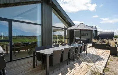 a dining room with a table and chairs on a deck at Pet Friendly Home In Saltum With Sauna in Saltum