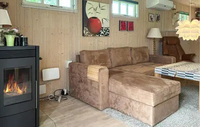 a living room with a couch and a fireplace at 2 Bedroom Cozy Home In Farsø in Farsø