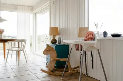 a living room with a table and chairs and a table at Cosy, Traditional Summer House Close To The North Sea in Fjerritslev