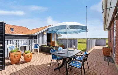 a patio with a table and chairs and an umbrella at Gorgeous Home In Vestervig With Wifi in Vestervig