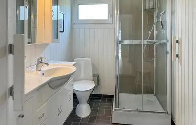 a bathroom with a toilet and a sink and a shower at 3 Bedroom Stunning Home In Øster Assels in Øster Assels