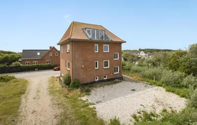an old brick house with a solar roof on a road at 3 Bedroom Amazing Home In Harboøre in Harboør