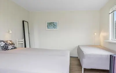 a white bedroom with two beds and a window at Amazing Home In Løkken With Wifi in Løkken