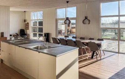 a kitchen with a sink and a table with chairs at Awesome Home In Vinderup With Sauna in Vinderup
