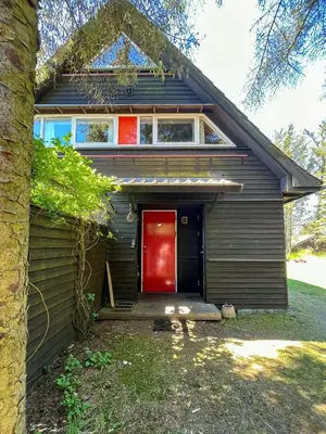 a house with a red door and a tree at Architect-Designed Holiday Home By Saltum Beach in Saltum