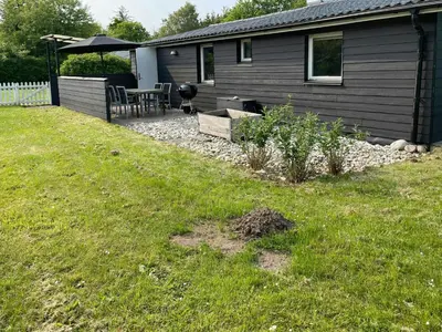 a backyard of a house with a table and chairs at Family House By Frederik Vii Canal In Løgstør in Løgstør