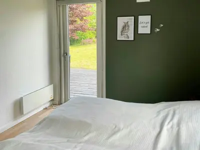 a bedroom with a bed and a door to a yard at Family House By Frederik Vii Canal In Løgstør in Løgstør