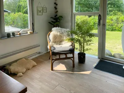 a room with a rocking chair and a potted plant at Family House By Frederik Vii Canal In Løgstør in Løgstør