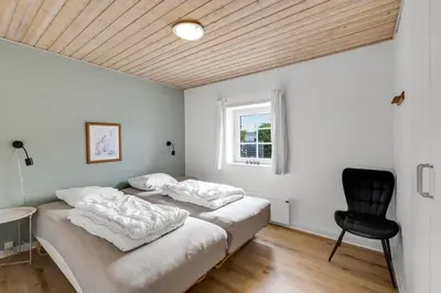two beds in a room with a desk and a chair at Large Pool House For 24 People, With Almost Everything In Activities, 300 Meters From The Fjord in Vinderup