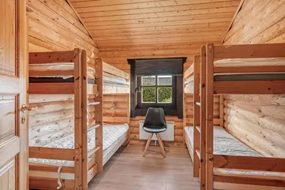 a bedroom with two bunk beds in a log cabin at Well-Maintained Log House With Hot Tub, Sauna And Covered Terrace In Thy
