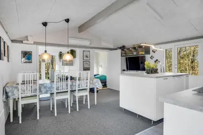 a kitchen and dining room with a table and chairs at Lovely Renovated Holiday Home With A Wilderness Bath And Fenced Grounds in Vesløs