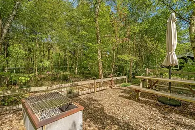 a patio with an umbrella and a bench and a table at Lovely Renovated Holiday Home With A Wilderness Bath And Fenced Grounds in Vesløs