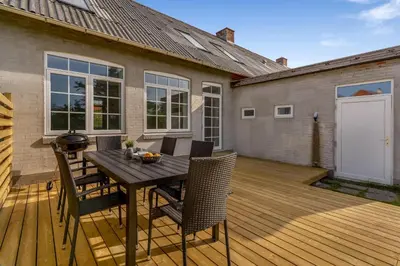 a wooden deck with a table and chairs on it at Renovated Holiday Home With Free Consumption, Close To The North Sea And The Center Of Hanstholm in Hanstholm