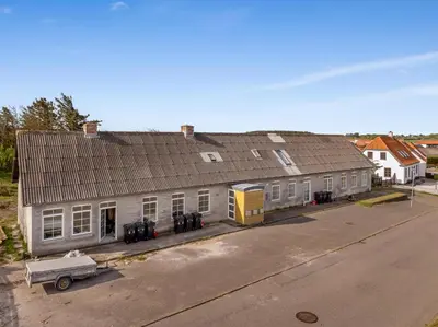 a large house with a truck parked in front of it at Renovated Holiday Home With Free Consumption, Close To The North Sea And The Center Of Hanstholm in Hanstholm