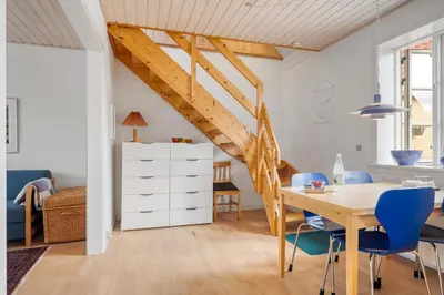 a dining room with a wooden table and blue chairs at Charming Townhouse From 1877, Located In The Middle Of Løgstør Only 100 Meters From The Harbor in Løgstør