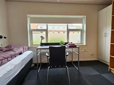 a bedroom with a desk and a bed and a window at Cozy Danish Room for Solo Stays in Lemvig