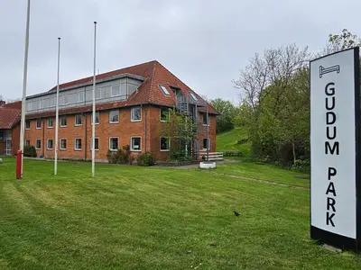 a large brick building with a sign in front of it at Compact standard single room in Lemvig in Lemvig