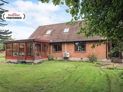 a brick house with a large yard in front of it at 10 person holiday home in Spøttrup in Spottrup