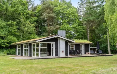 a small white cottage with a grass roof at Amazing Home In Roslev With Wifi in Roslev