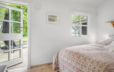 a bedroom with a bed and two windows at Amazing Home In Roslev With Wifi in Roslev
