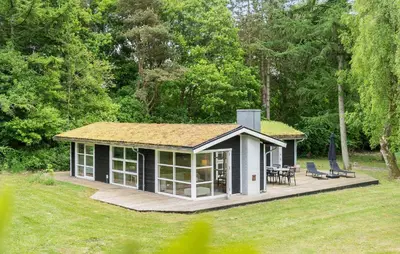 a small cottage with a deck in a yard at Amazing Home In Roslev With Wifi in Roslev