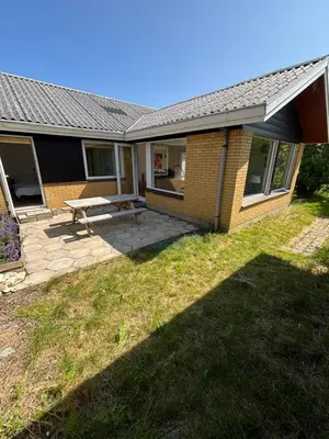 a house with a picnic table in the yard at Viking Surf Home in Klitmøller
