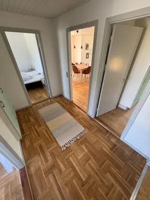 a room with a wooden floor and a dining room at Viking Surf Home in Klitmøller