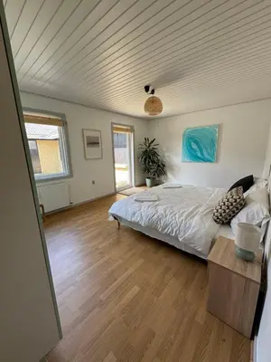 a bedroom with a bed and a wooden floor at Viking Surf Home in Klitmøller