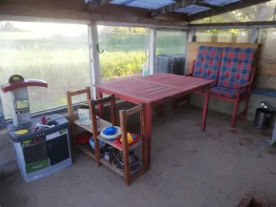a table and a chair in a room with a stove at Holiday Home Kirkeby Feriehus in Roslev