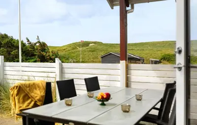 a table and chairs on a patio with a white fence at Awesome Home In Harboøre in Harboør