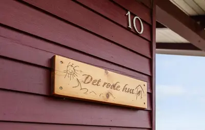 a wooden sign on the side of a purple building at Awesome Home In Harboøre in Harboør