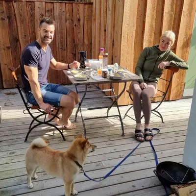 a man and a woman sitting at a table with a dog at Koppes Mølle B&B - naturnær overnatning in Borup