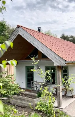 a small white house with a red roof at Koppes Mølle B&B - naturnær overnatning in Borup