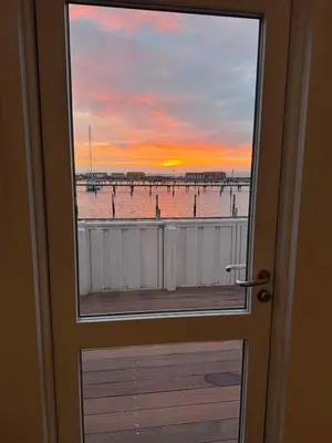 a view of the beach from a door with a window at Cozy harbor house in Nibe in Nibe