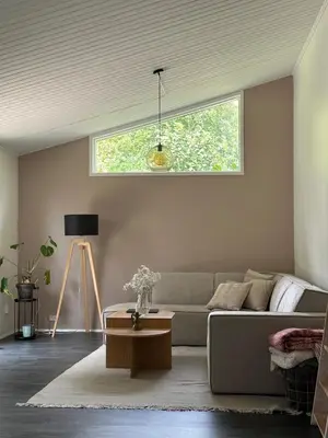 a living room with a couch and a window at Sjarmerende og hyggelig lite hjem in Holstebro