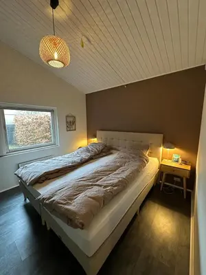 a bedroom with a large bed and a window at Sjarmerende og hyggelig lite hjem in Holstebro