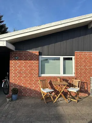 two chairs and a table in front of a brick house at Sjarmerende og hyggelig lite hjem in Holstebro