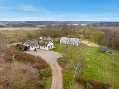 an aerial view of a white house in a field at Holiday Home Åsta - 400m to the fjord by Interhome in Roslev